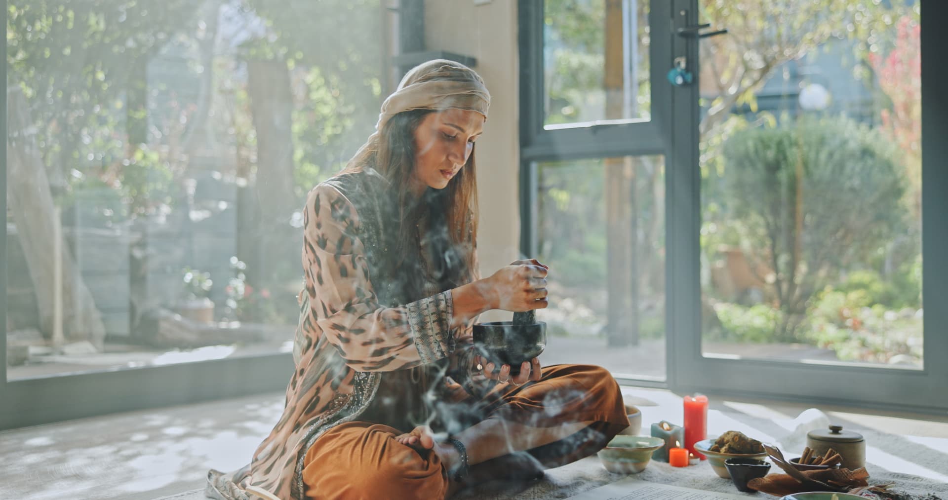 Smoke rising as Noa works with plant medicine in sunlit stillness